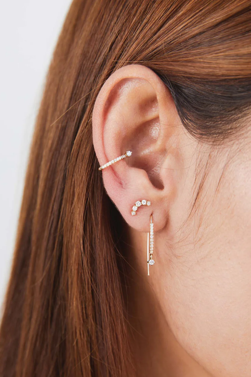 model wearing 5 Graduated Prong Diamond Curved Bar Studs earrings 14k gold