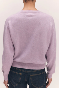 back profile model wearing  Ada Crew Neck Cardigan Pansy Purple lambswool crewneck long sleeve white button closure ribbed cuff and hem