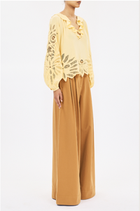 side profile model wearing  Adonis Silk Top dandellion yellow Botanical embroidery
Silk crepe de chine
Relaxed fit
V-neckline with ruffles long sleeves with elastic cuffs
Pullover style