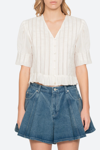 front profile model wearing Alberte Top white cotton V-neckline
Short sleeves
Delicate pintuck pleats
Subtle peplum hem
button front