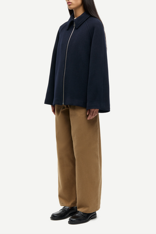 side profile model wearing Alma Wool Blend Zip Front Jacket navy blue pointed collar relaxed fit raglan sleeves