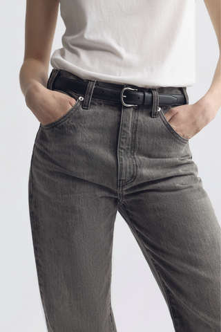 model wearing  Amelia Belt black 25mm wide belt
Italian smooth leather
Lightweight suede lining in a contrasting natural hue
Bombe construction
Custom silver-tone hardware
100% Calfskin Leather