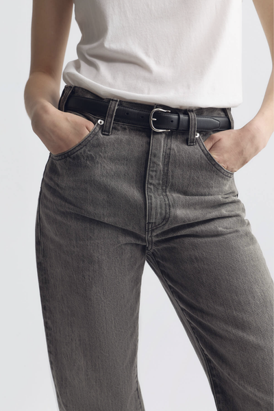 model wearing  Amelia Belt black 25mm wide belt
Italian smooth leather
Lightweight suede lining in a contrasting natural hue
Bombe construction
Custom silver-tone hardware
100% Calfskin Leather