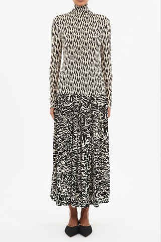 front profile model wearing  Aurelia Jersey Turtleneck Top Silhouette Wavy vines evocative of feathery motion print
Tricot lightweight jersey
close fit
Turtleneck
Long sleeves
Pullover style