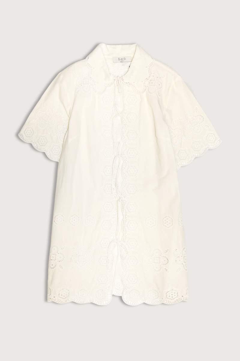 flat lay Babette Eyelet  Tie Front Coverup white Breezy mini silhouette
All-over eyelet detailing
Scalloped edges
Short sleeves
Front tie closures
Relaxed fit
Self: 100% cotton
Embroidery: 100% Polyester