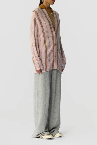 side profile model wearing Baja Oversized Cardigan pink combo 
Three-button closure
Shawl collar stand
JACQUARD THREE-COLOR STRIPED
HORIZONTAL KNIT

SELF-FINISH AT HEMS
Signature GIR branding at center back neck