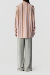 back profile model wearing Baja Oversized Cardigan pink combo 
Three-button closure
Shawl collar stand
JACQUARD THREE-COLOR STRIPED
HORIZONTAL KNIT

SELF-FINISH AT HEMS
Signature GIR branding at center back neck
