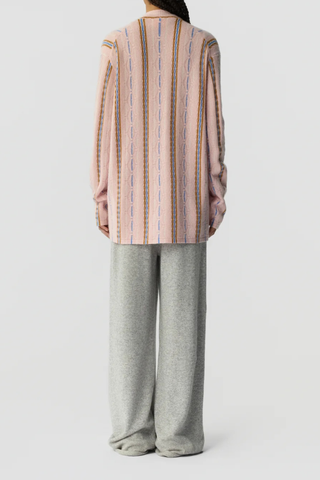 back profile model wearing Baja Oversized Cardigan pink combo 
Three-button closure
Shawl collar stand
JACQUARD THREE-COLOR STRIPED
HORIZONTAL KNIT

SELF-FINISH AT HEMS
Signature GIR branding at center back neck