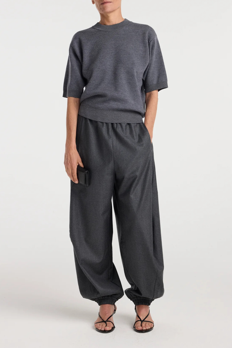 front profile model wearing Balloon Track Wool Pant dark grey melange Balloon track pants
Soft dark grey wool
Elasticated waistband and hem
Voluminous leg
Front welt pockets