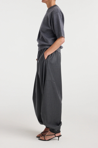 side profile model wearing Balloon Track Wool Pant dark grey melange Balloon track pants
Soft dark grey wool
Elasticated waistband and hem
Voluminous leg
Front welt pockets