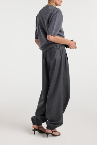 back profile model wearing Balloon Track Wool Pant dark grey melange Balloon track pants
Soft dark grey wool
Elasticated waistband and hem
Voluminous leg
Front welt pockets
