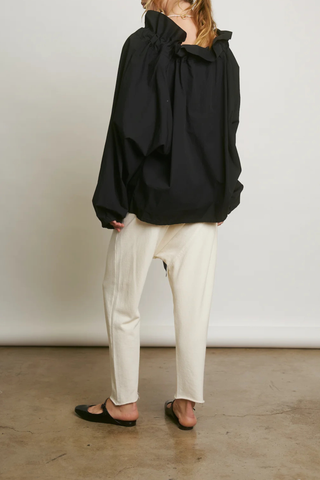 back profile model wearing  Beautiful Mess Top Black Bow neck
puff sleeves
Grand ruffle neck cinched in with lovely wide ribbon
Long sleeve
Elastic cuff
Straight hem

Relaxed fit
100% Cotton