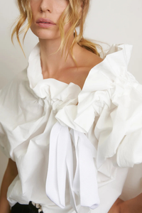 front profile model wearing Beautiful Mess Top Cloud white Bow neck
puff sleeves
Grand ruffle neck cinched in with lovely wide ribbon
Long sleeve
Elastic cuff
Straight hem
100% Cotton