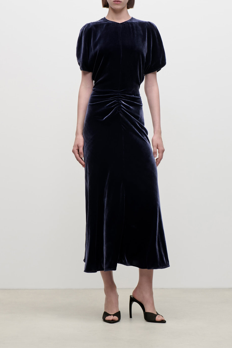 front profile model wearing  Bela Silk Velvet Dress navy Midi-length
Silk viscose velvet

Soft, fluid drape
Mid weight piled velvet
Round front neckline
V-shaped back
Front waist gather
82% Viscose 18% Silk