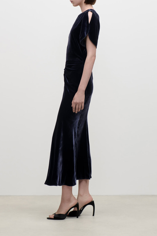 side profile model wearing  Bela Silk Velvet Dress navy Midi-length
Silk viscose velvet

Soft, fluid drape
Mid weight piled velvet
Round front neckline
V-shaped back
Front waist gather
82% Viscose 18% Silk