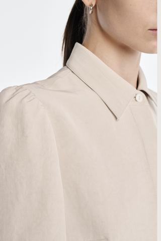 close up collar detail Bell Sleeve Blouse champagne Bell Sleeve blouse
Naia Sateen
Signature corozo buttons and covered placket
Slim fit blouse
100% Acetate