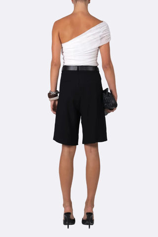 back profile model wearing  Bella Culotte Shorts Black long shorts
Button closure
Elegant pleats
High-rise fit
Relaxed fit