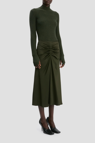 side profile model wearing  Bella Skirt dark olive green midi length gathered waist flared hem