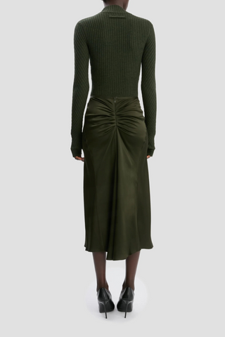 back profile model wearing  Bella Skirt dark olive green midi length gathered waist flared hem