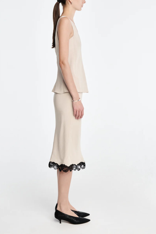 side profile model wearing Bias Skirt champagne
Matte sateen
 black floral lace trim
Cotton corded lace
Cut on the bias
Delicate lingerie stitch elastic waistband
Knee-length
100% Naia acetate
