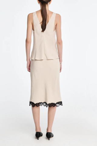 back profile model wearing Bias Skirt champagne
Matte sateen
 black floral lace trim
Cotton corded lace
Cut on the bias
Delicate lingerie stitch elastic waistband
Knee-length
100% Naia acetate