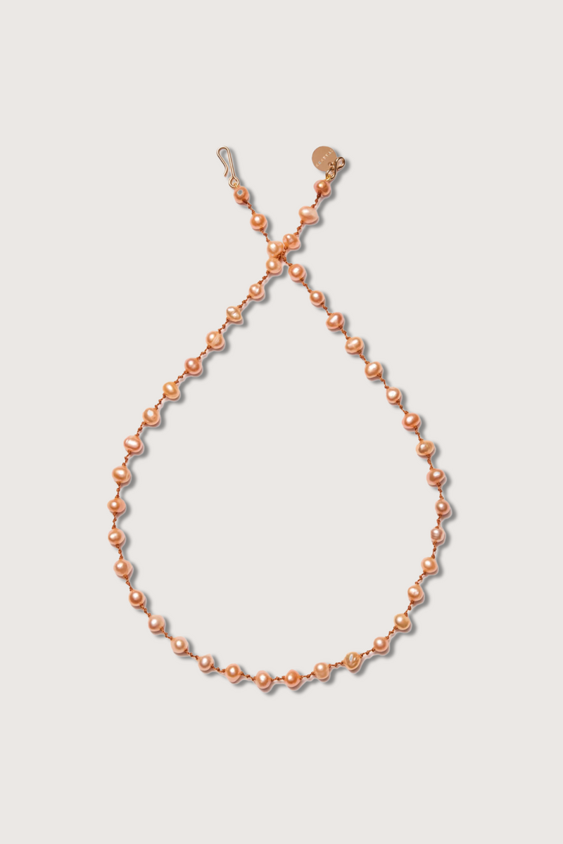 flat lay Bird Peach Freshwater Pearl Necklace with infinity 14K gold-filled clasp