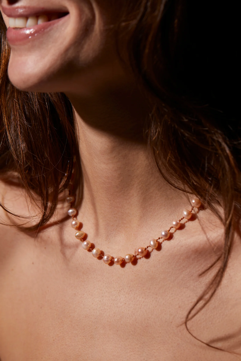 model wearing Bird Peach Freshwater Pearl Necklace with infinity 14K gold-filled clasp