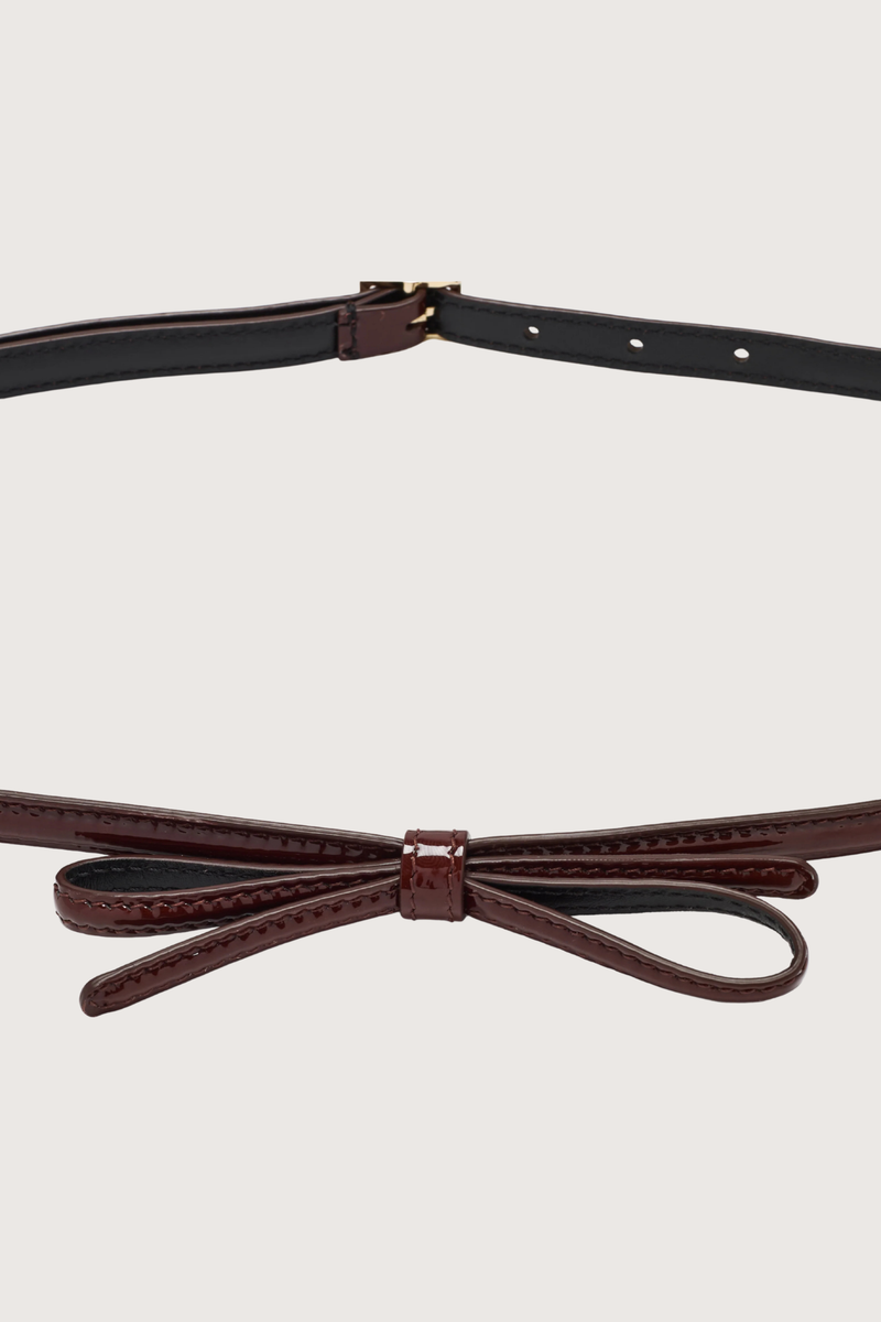 close up bow detail for Bow Belt bark brown Skinny belt
Bark calf naplack leather
Bow detail on the front
Adjustable back closure with a metal buckle
98% Domesticated calf leather | 2% Metal
