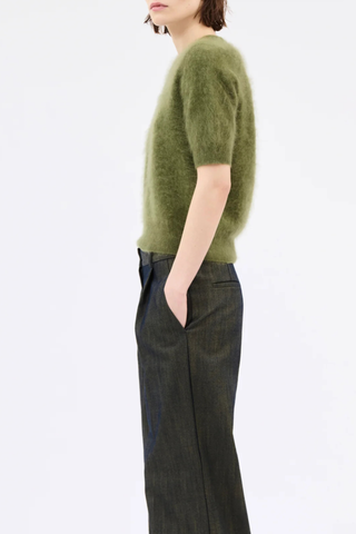 side profile model wearing  Brushed Cashmere Short Sleeve Sweater moss green High ribbed collar