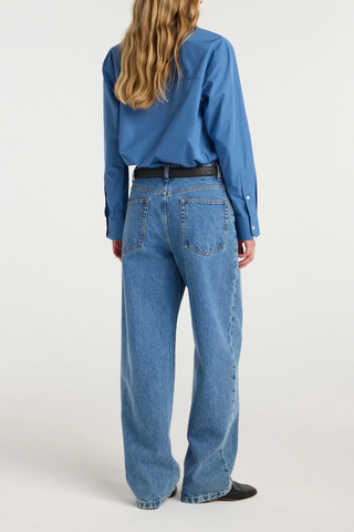 back profile model wearing  Bruun Signature Baggy Denim heritage mid wash blue Classic denim
Pure cotton in a denim blue tone
Low-waist fit
Elongating wide baggy leg
Branded metal button
100% cotton