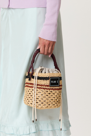 model wearing Bucket Straw Bag natural Woven straw bucket bag
Contrast striped pattern
Braided handle
Signature logo patch