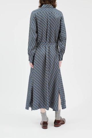 back profile model wearing Button Down Long Sleeve Silk Dress admiral blue geometric mini pattern attached waist tie high side slit hidden button closure midi length