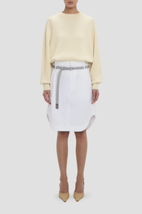 front profile model wearing Cargo Skirt optic white A-line shape
Mid rise
Knee length
Zip fly with double hook &amp; bar closure
Self fabric waistband with internal trim
Belt loops
Button closed pocket
100% Cotton