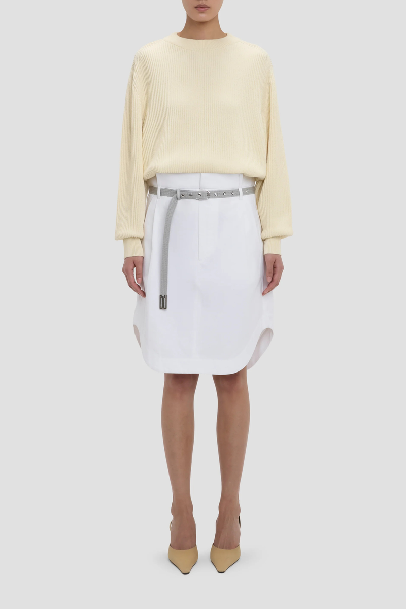 front profile model wearing Cargo Skirt optic white A-line shape
Mid rise
Knee length
Zip fly with double hook &amp; bar closure
Self fabric waistband with internal trim
Belt loops
Button closed pocket
100% Cotton