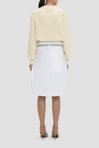 back profile model wearing Cargo Skirt optic white A-line shape
Mid rise
Knee length
Zip fly with double hook &amp; bar closure
Self fabric waistband with internal trim
Belt loops
Button closed pocket
100% Cotton