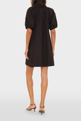 back profile model wearing Carleigh Ruffle Neck Dress Black cotton Crisp paper poplin with a refined feel
Mini dress
Deep V-neck
Ruffle detailing
Shirred puff sleeves
Side seam pockets