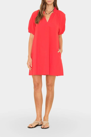 front profile model wearing Carleigh Ruffle Neck Dress Red cotton Crisp paper poplin with a refined feel
Mini dress
Deep V-neck
Ruffle detailing
Shirred puff sleeves
Side seam pockets