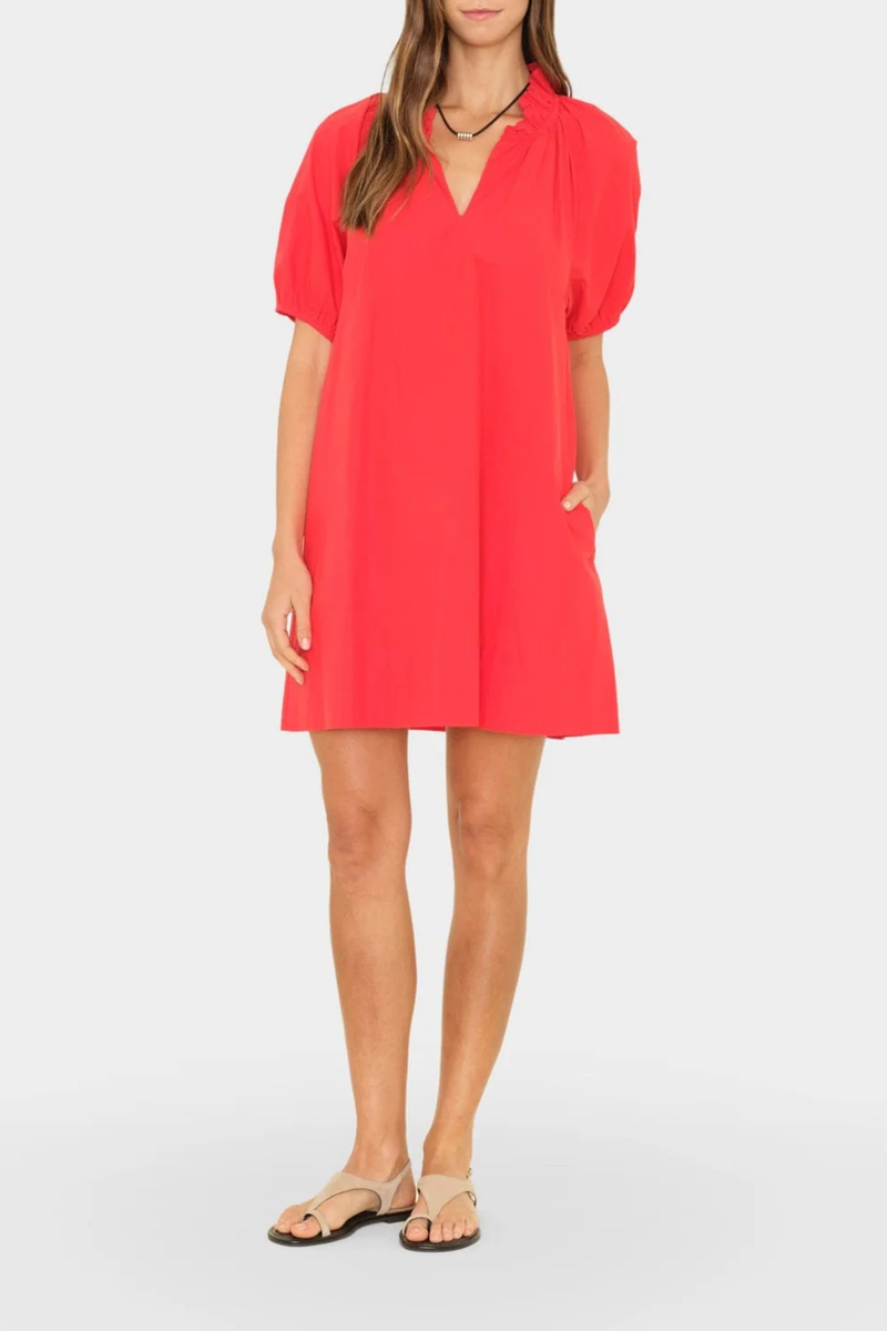 front profile model wearing Carleigh Ruffle Neck Dress Red cotton Crisp paper poplin with a refined feel
Mini dress
Deep V-neck
Ruffle detailing
Shirred puff sleeves
Side seam pockets