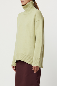 side profile model wearing Cashmere T-neck Sweater Cashmere T-neck Sweater pistachio, green Ribbed turtleneck, 
Ribbed cuff and hem, Relaxed fit