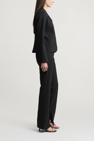 side profile model wearing Charlie Tropical Wool Long Trouser black Slim leg
Straight tailored trouser
Tropical wool suiting
Split hem
Mid-rise
Extended hook
Button tab closure at the waist
Belt loops
Side seam pockets
Sharp center front crease
Single back welt pocket