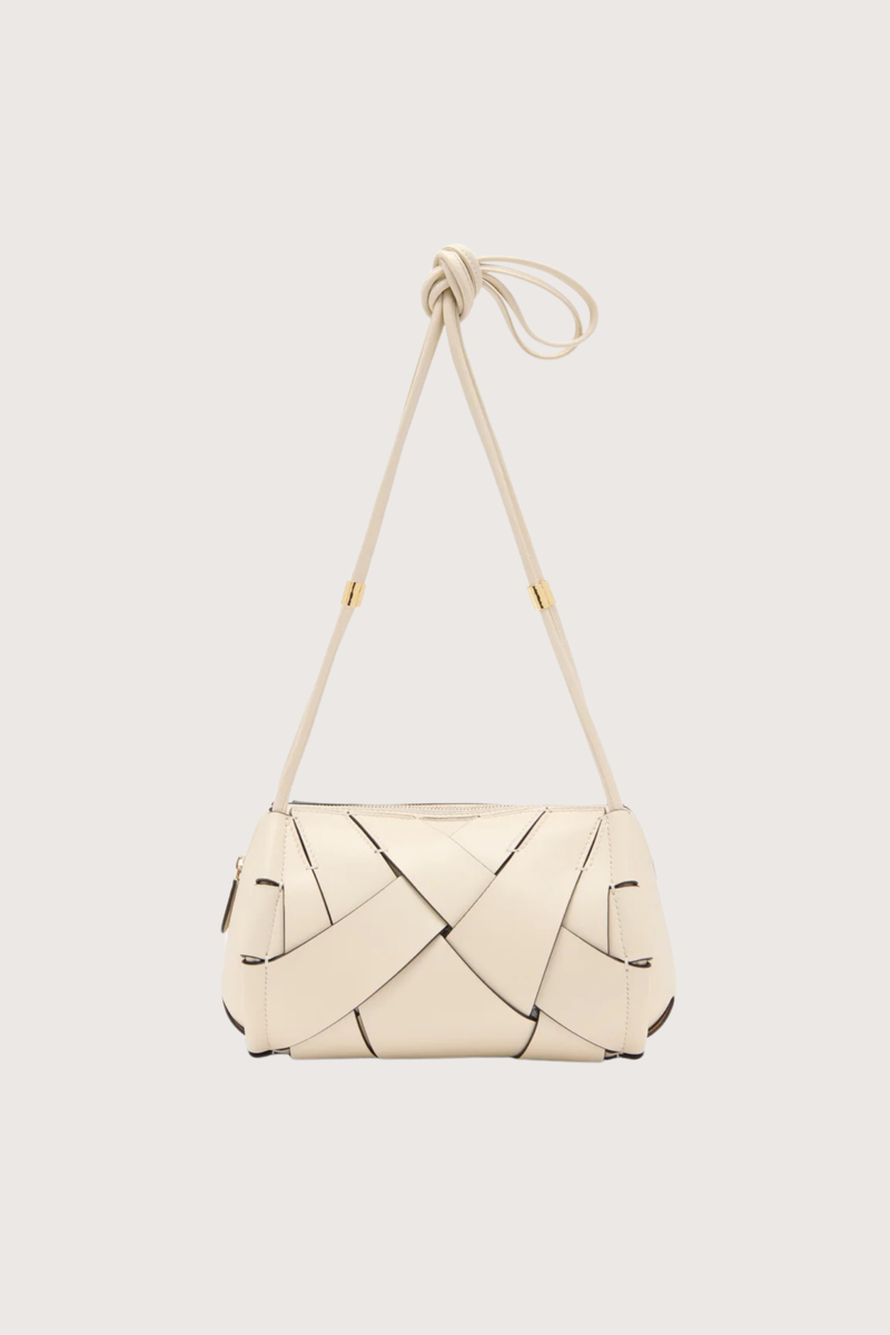 flat lay Charlotte Camera Bag Cowrie cowrie white
Hand-woven
Thick tubular strap
Worn crossbody or on the shoulder
Suede interior
Calfskin nappa leather
Hammered antique brass sliders
Zipper along top