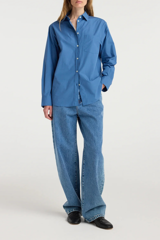 front profile model wearing A classic button-down
Deep blue cotton
Relaxed fit
Patch pocket at the chest
Subtly rounded hem
100% cotton