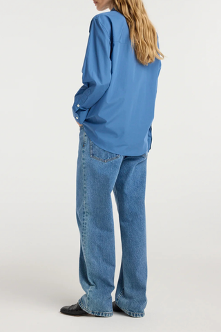 back profile model wearing A classic button-down
Deep blue cotton
Relaxed fit
Patch pocket at the chest
Subtly rounded hem
100% cotton
