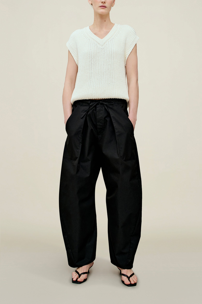 front profile model wearing Clemence Compact Cotton horseshoe Pant black with adjustale drawstring and pleats