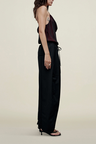 side profile model wearing Clemence Pant black relaxed fit Sculptural horseshoe shaped
Pleated front construction
Patch pocket at front