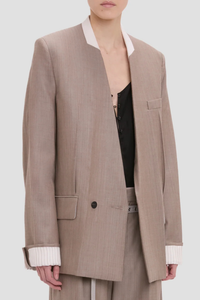 side profile model wearing Collarless Jacket limestone Seat length
Half double breasted
Collarless
Long sleeve
Oversized shoulder
Laundry press
Flap pocket
Full lining
100% Wool