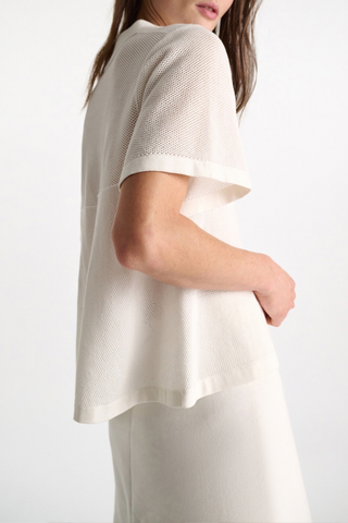 side profile model wearing Cotton Coolness Mesh Top white Knit top with polo collar and empire waist
Sporty stretch cotton pointelle
A special engineered knit technique creates flared volume from the empire seam to hem