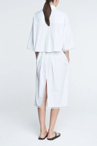back profile model wearing Cropped Lace Shirt white delicate, ivory French lace detail at the cuff
Shorter, cropped length
Center box pleat at the back
Wide, short sleeves
Organic Cotton sateen