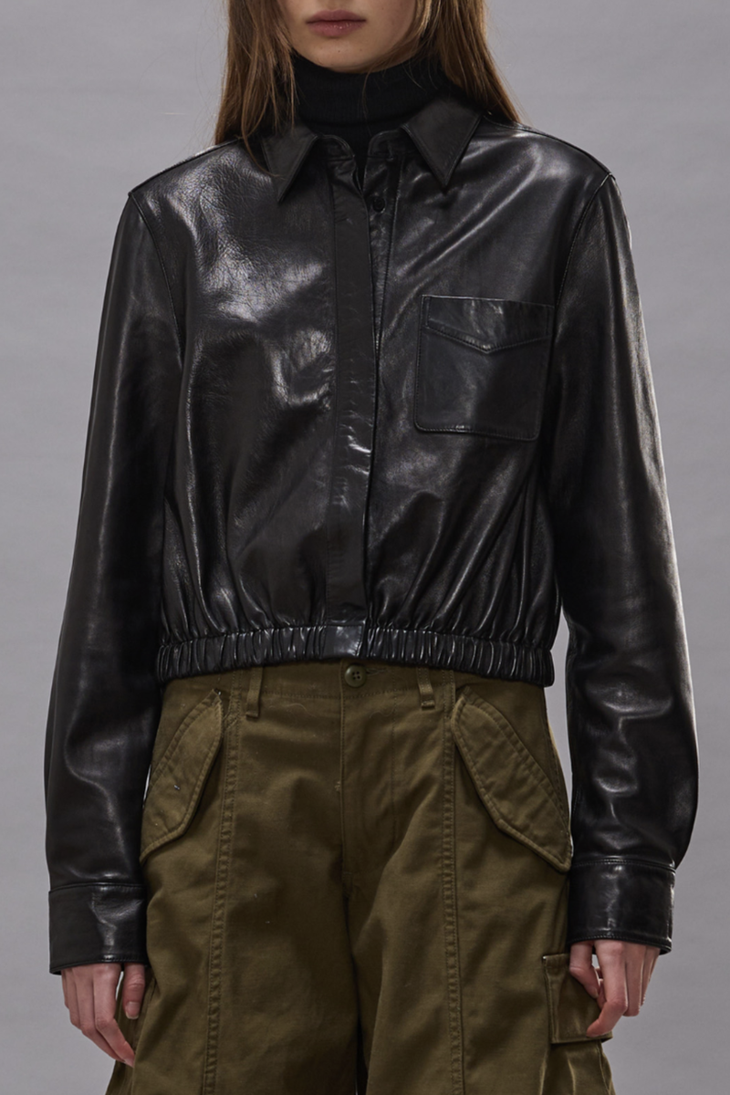 front profile model wearing Cropped Leather Boxy Shirt black Classic collar
Cropped fit
Elasticated waist
Chest pocket
Top and bottom snap buttons
Hidden traditional button closure for middle buttons
100% Italian lamb leather