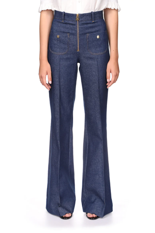 front  profile model wearing Danae High Waisted Flared denim Pants with front pockets and gold exposed zipper closure